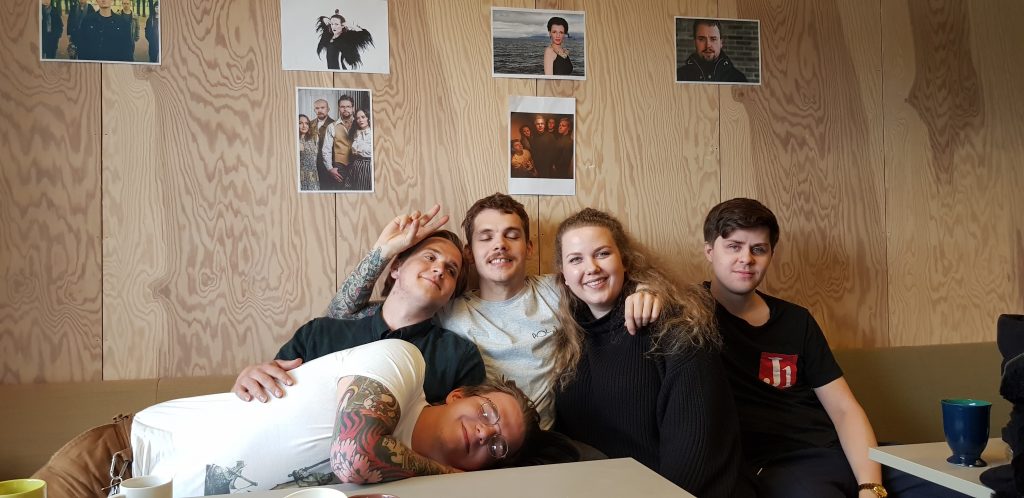 Five young people in a sofa. Photo.